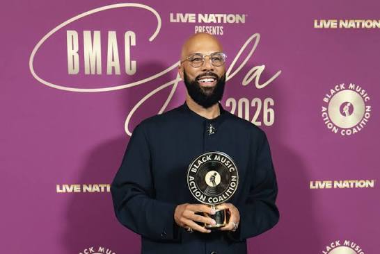 Common smiling and holding his BMAC award in front of the BMAC Gala 2026 backdrop