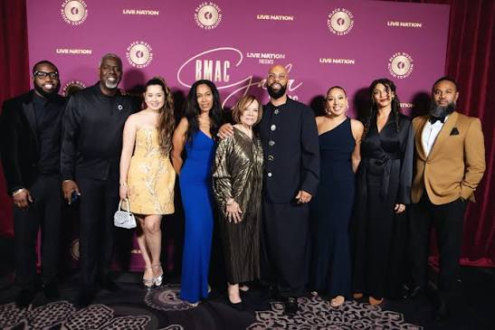 Common posing with a group of guests on the BMAC Gala 2026 red carpet