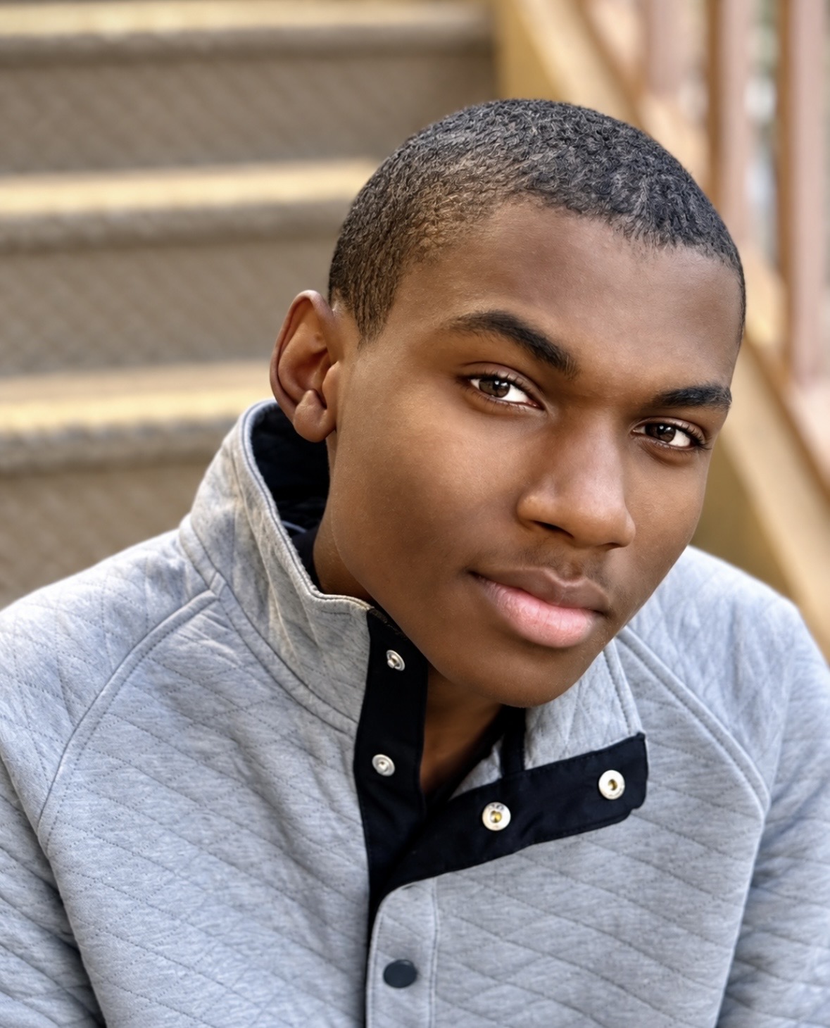 Headshot of actor Christopher Bates in a gray quilted pullover