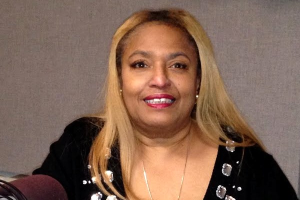 Portrait of Florence &ldquo;Flo&rdquo; Anthony smiling in a black beaded top during a radio interview.