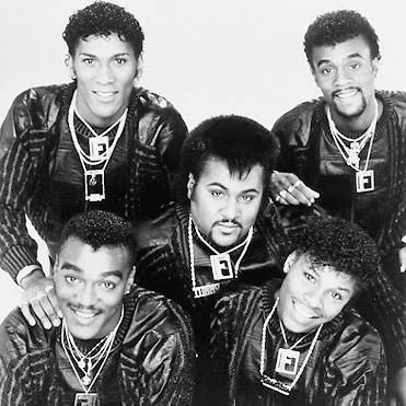 A vintage black-and-white portrait of the Force MDs in matching sweaters and chains during their early years