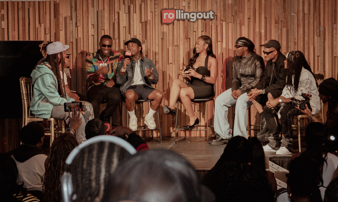 Jacquees speaks on stage in front of a Rolling Out backdrop as moderator Brook Ellison and guests look on, with the audience seated in the foreground.