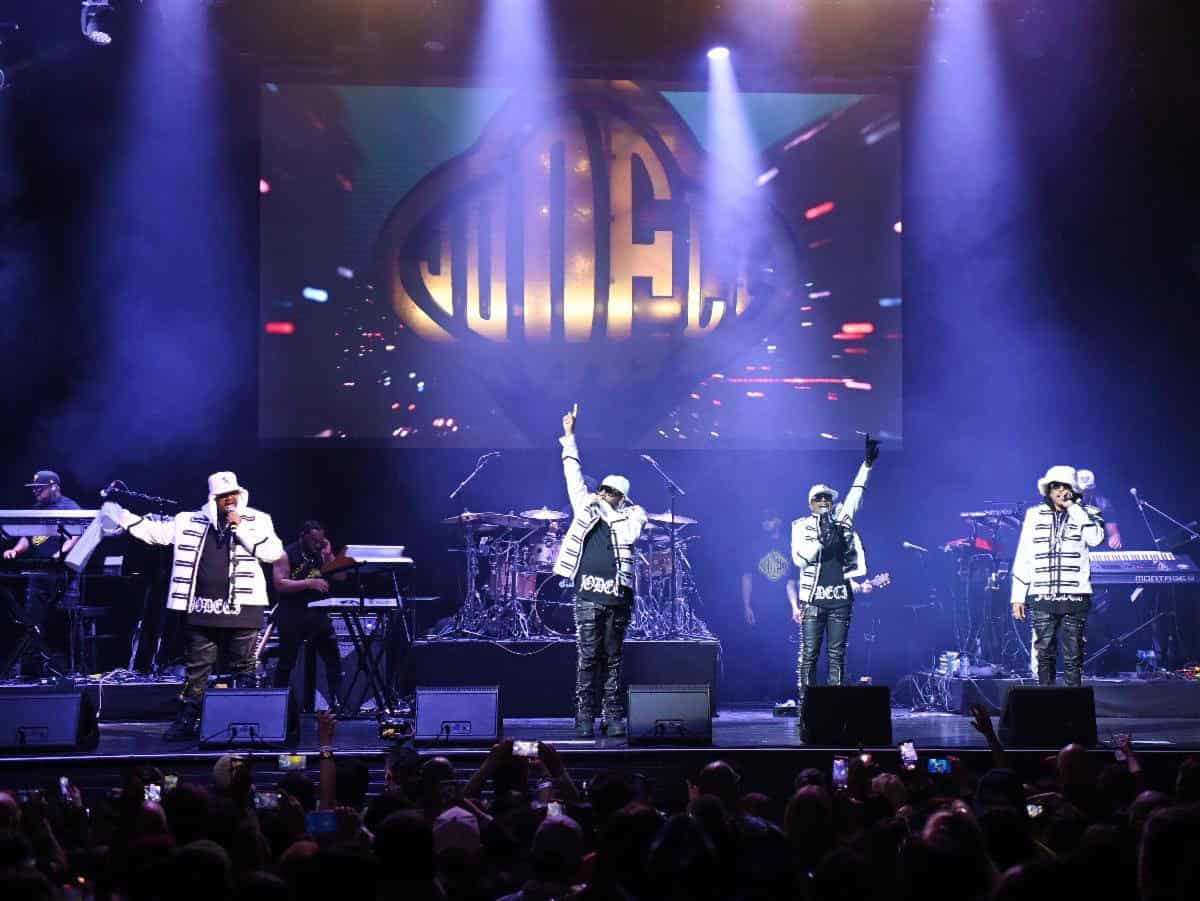 Jodeci performing live on stage beneath the group&rsquo;s logo