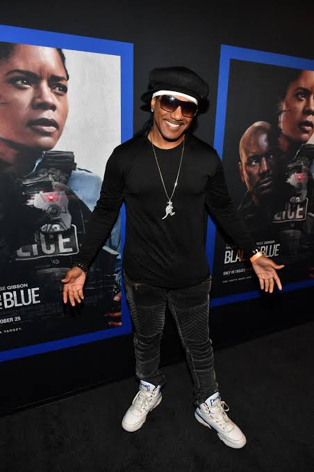 Kangol Kid on a movie premiere red carpet in later years, dressed in all black with his Kangol cap.