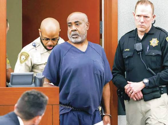 Duane &ldquo;Keffe D&rdquo; Davis, in dark blue jail clothing and shackles, escorted into a Las Vegas courtroom by two officers.