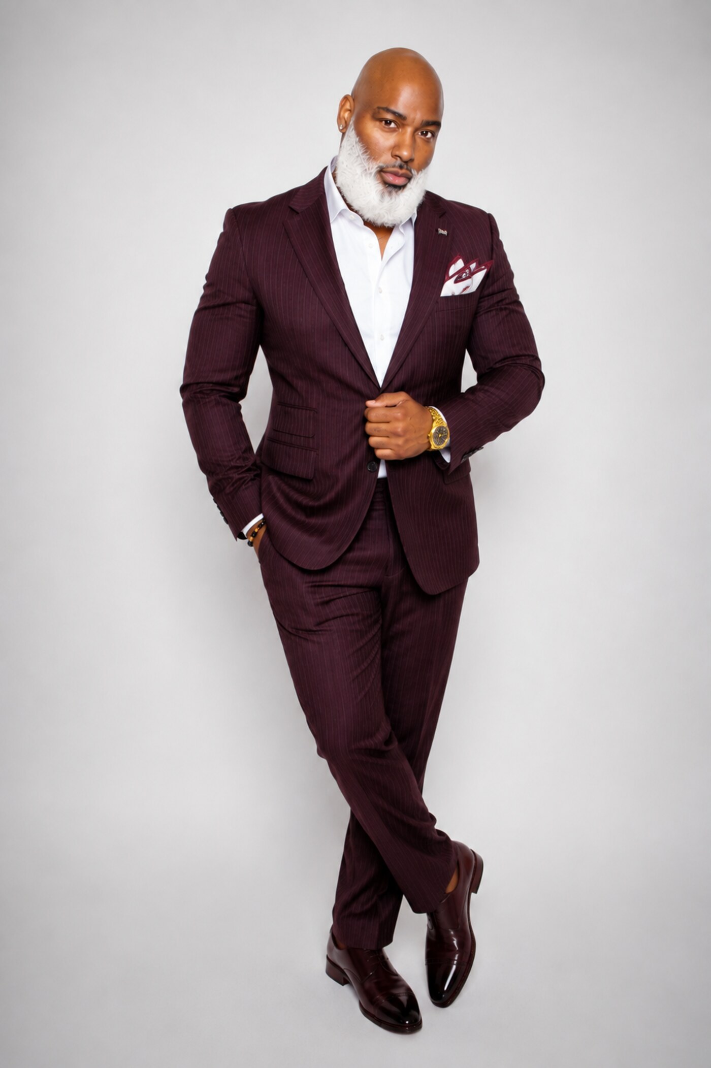 Rob Malloy standing in a burgundy pinstripe suit with a white shirt and patterned pocket square.