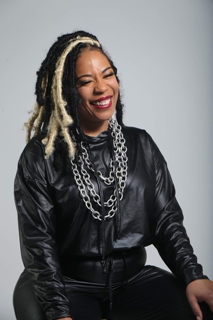 Portrait of Tiffany &ldquo;T.Barb&rdquo; Barber in a black leather jacket with layered silver chains.