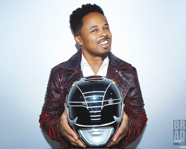 Walter E. Jones holding the Black Ranger helmet from Mighty Morphin Power Rangers.